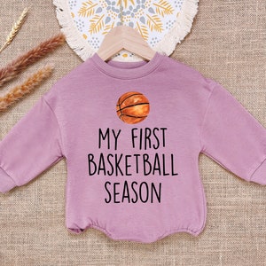 May include: A purple long-sleeved sweatshirt with the text "My First Basketball Season" and a basketball graphic.