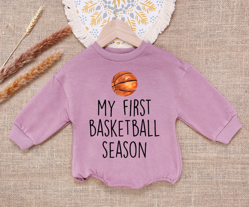 May include: A purple long-sleeved sweatshirt with the text "My First Basketball Season" and a basketball graphic.