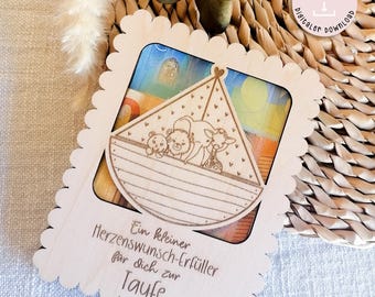 May include: Wooden cutout of a boat with animals inside. The boat is on a wooden background with the text "Ein kleiner Herzenswunsch-Erfüller für dich zur Taufe".