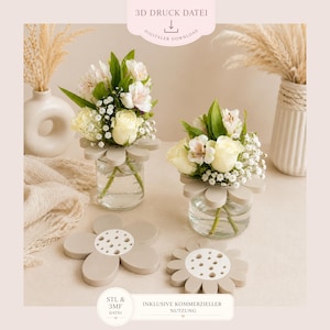 May include: Two small glass vases with flower-shaped bases hold bouquets of white roses and other flowers. The vases sit on a light-coloured surface, with two flower-shaped coasters nearby. The image includes text that reads "3D DRUCK DATEI" and "DIGITALER DOWNLOAD."