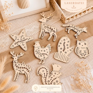 May include: A collection of wooden ornaments in various shapes, including a deer, fox, owl, and squirrel, with intricate floral and leaf patterns. The ornaments are light brown and have a rustic, handmade appearance. The text "INKLUSIVE KOMMERZIELLER NUTZUNG" is visible.