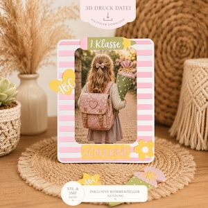 May include: A rectangular photo frame with pink and white horizontal stripes, featuring a top pencil-shaped accent labeled 1.Klasse, a yellow heart with ABC, and a bottom yellow label reading SCHULKIND with a flower, designed as a 3D print file.