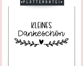 May include: Black and white printable design with the text "KLEINES DANKESCHÖN" and a small heart in the center of a wreath of leaves. The text "PLOTTERDATEI" is at the top of the design and the text "LOVELY.kreativWerk" is at the bottom.