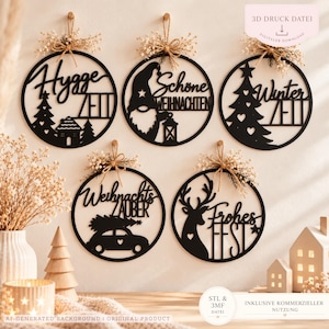 Puede incluir: Cinco decoraciones de pared circulares negras con diseños recortados y texto en alemán: Hygge Zeit, Schöne Weihnachten, Winter Zeit, Weihnachts Zauber y Frohes Fest. Cada pieza está rematada con un pequeño ramo de flores secas.
