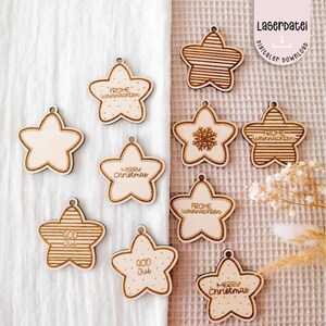 May include: Ten wooden star ornaments with laser-cut designs. The ornaments feature various Christmas greetings in English and German, including "Merry Christmas", "Frohe Weihnachten", and "God Jul".
