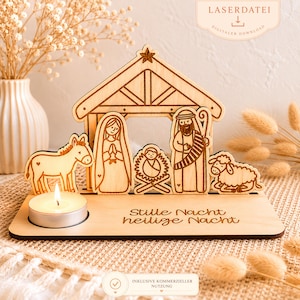 May include: A wooden nativity scene with a candle. The scene includes a stable, Mary, Joseph, baby Jesus, a donkey, and a sheep. The base has the words "Stille Nacht, heilige Nacht" engraved. A small candle is lit in front of the scene.