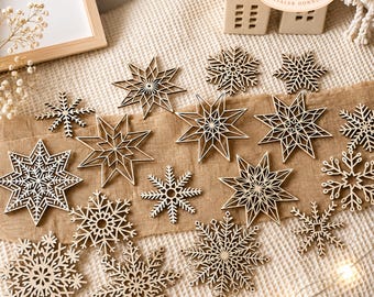 May include: A collection of wooden snowflake ornaments in various sizes and designs. The laser-cut snowflakes are arranged on a neutral-toned surface, with some featuring intricate starburst patterns. The image includes text that reads "LASERDATEI DIGITALER DOWNLOAD" and "INKLUSIVE KOMMERZIELLER NUTZUNG".