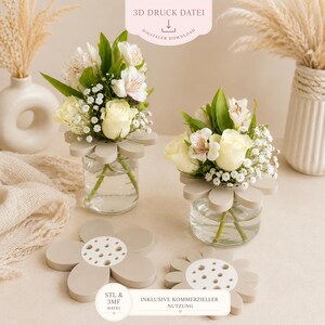 May include: Two small glass vases with flower arrangements, featuring white roses and other flowers, sit on a beige surface. The vases have a daisy-shaped holder. The image also shows two daisy-shaped holders and text that reads "3D DRUCK DATEI" and "DIGITALER DOWNLOAD".