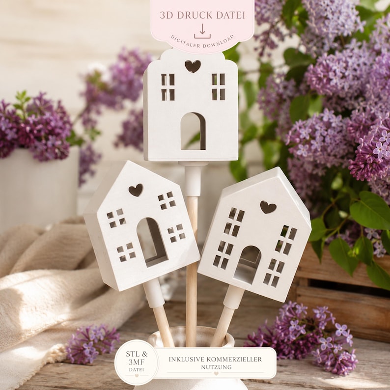 May include: Three white house-shaped ornaments with heart cutouts and window details. The houses are mounted on wooden sticks and arranged in a white vase. The image includes text that says "3D DRUCK DATEI" and "DIGITALER DOWNLOAD".