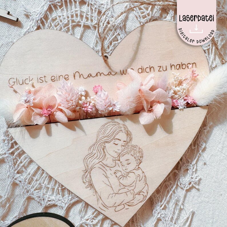 May include: A wooden heart-shaped sign with a floral design and the text "Gl&uuml;ck ist eine Mama wie dich zu haben". The sign also features a laser-cut image of a mother holding a child.