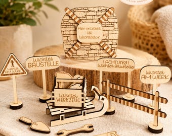 May include: A collection of laser-cut wooden miniatures, including signs, tools, and a brick-like structure. The signs feature text in German. The set includes a shovel, wrench, and a toolbox, all in natural wood tones.
