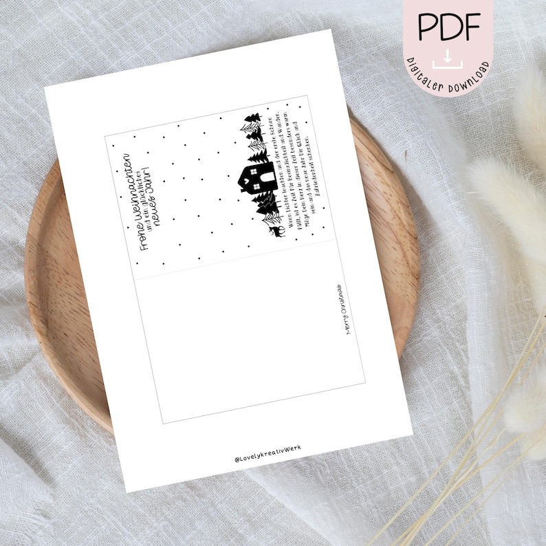 May include: A printable Christmas card with a black and white illustration of a house in a snowy forest. The text on the card reads "Frohe Weihnachten und ein gl&uuml;ckliches neues Jahr!" which translates to "Merry Christmas and a Happy New Year!" in English.