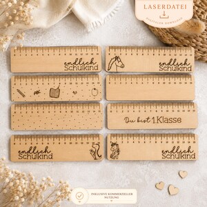 May include: A collection of wooden rulers with laser-etched designs and measurements up to 15 inches. Some rulers feature text like "endlich Schulkind" and "Du bist 1.Klasse", along with illustrations of a horse, pencil, book, apple, and a dinosaur.