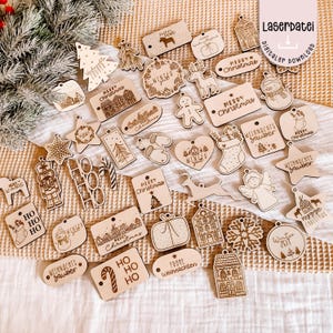 May include: A collection of laser-cut wooden Christmas ornaments in various shapes, including stars, houses, and gift boxes. Many ornaments feature festive text like "Merry Christmas" and "Winter". The ornaments are unpainted and have a natural wood finish.