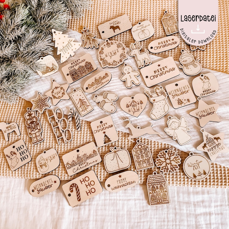 May include: A collection of laser-cut wooden Christmas ornaments in various shapes, including stars, houses, and gift boxes. Many ornaments feature festive text like "Merry Christmas" and "Winter". The ornaments are unpainted and have a natural wood finish.