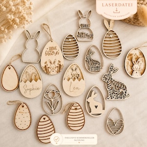 Könnte beinhalten: Eine Sammlung von hölzernen Osterdekorationen, darunter Hasen- und Eierformen. Einige Eier haben eingravierte Designs, Namen oder den Schriftzug "Frohe Ostern". Die Dekorationen sind hellbraun mit Kordelaufhängern.