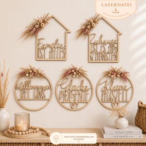 May include: Five laser-cut wooden wall signs in house and circular shapes, featuring German text and dried floral arrangements. The signs include phrases like Familie ist alles, Zuhause ist es am schönsten, Willkommen bei uns, Glucks Momente, and Kleine Auszeit.