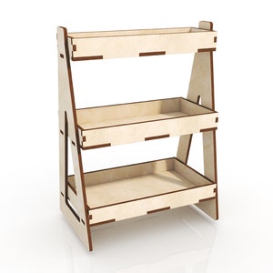 May include: A three-tier wooden shelf unit with a light brown finish. The shelves are made of plywood and have a slightly raised edge. The unit is freestanding and has a triangular shape.