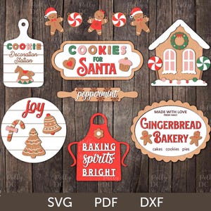 Puede incluir: Un conjunto de 10 archivos de corte SVG con temática navideña que incluyen galletas de jengibre, una casa de jengibre y letreros que dicen "Galletas para Santa", "Alegría", "Menta", "Hornear espíritus brillantes" y "Panadería de jengibre".