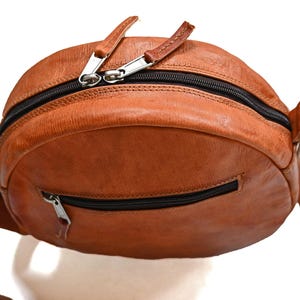 Handgenähte runde Tasche aus natürlich gegerbtem Leder. Trageriemen der Umhängetasche ist der Länge verstellbar. 
Ansicht der Tasche von Oben.
