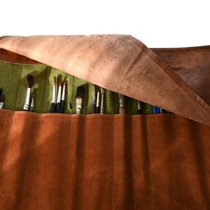 Handgefertigte Werkzeugrolle aus natürlich gegerbtem Leder mit Rausfallschutz durch Klappe . Zehn Fächer für Werkzeug, Pinsel, Stifte.