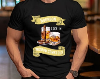 May include: Black t-shirt with a graphic featuring two glasses of bourbon and cigars. The text on the shirt reads "Bourbon Goes In, Wisdom Comes Out" in a banner design. The shirt is a crew neck.