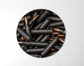 May include: A close-up image of a pile of spent bullet casings. The casings are mostly black with copper tips.