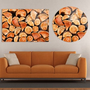 May include: A close-up of a stack of cut logs, with the wood grain visible. The logs are arranged in a circular pattern, with the ends of the logs facing the viewer. The logs are a warm brown color, with some areas of the wood being a lighter shade of brown. The logs are arranged in a random pattern, with some logs being stacked on top of others. The logs are arranged in a way that creates a sense of depth and texture.