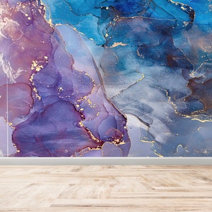 May include: Abstract art print featuring swirling blue, purple, and gold paint. The colours blend together to create a unique and eye-catching design.