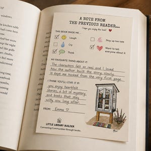 Pode incluir: Um cartão cor de creme intitulado A NOTE FROM THE PREVIOUS READER com caixas de seleção para reações do leitor, notas manuscritas sobre o livro e uma pequena ilustração de uma biblioteca. O cartão está colocado sobre uma página de livro.