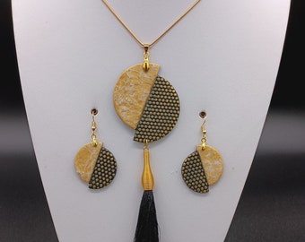 Romantische lange ketting van zwart en goud polymeer met geometrische pompon en oorbellen