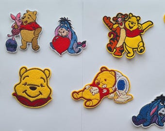 May include: A collection of embroidered patches featuring characters from Winnie the Pooh. The patches depict Pooh, Piglet, Eeyore, and Tigger in various poses, with vibrant colors and detailed stitching. These patches are ideal for decorating clothing or accessories.