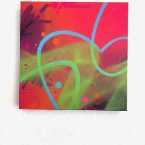 May include: Square canvas art with a vibrant abstract design. The artwork features a bright red background with a dotted texture, overlaid with neon green and blue lines, and splashes of pink and orange.