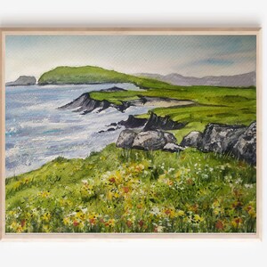 May include: A watercolor painting of a coastal landscape with a green hill, a rocky shoreline, and a blue ocean. The foreground features a field of wildflowers in shades of yellow, white, and red.