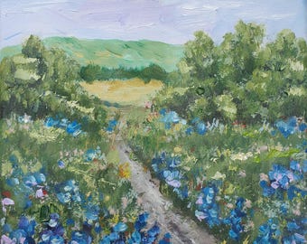 Könnte beinhalten: Ölgemälde, das einen Weg durch ein Feld blauer Wildblumen zeigt. Grüne Bäume und sanfte Hügel säumen den Weg unter einem Himmel in blassen Blau- und Lavendeltönen. Das Kunstwerk erzeugt ein Gefühl von Frieden und Ruhe.