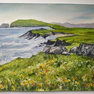 May include: Watercolor painting of a green grassy cliff overlooking a blue ocean with white waves. The cliff is covered in small yellow and white flowers.