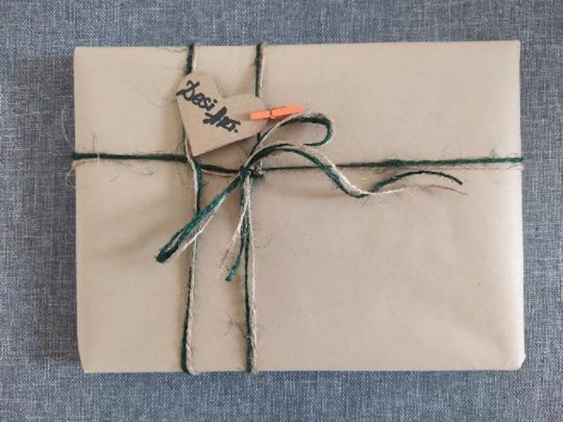 May include: A brown paper package tied with green and brown twine. A heart-shaped tag with the word "Besties" is attached to the package.