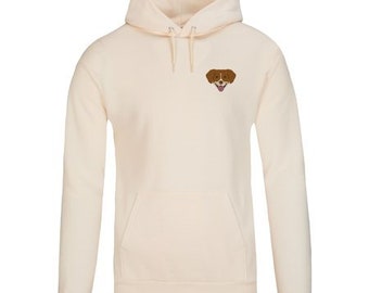 May include: A cream-colored hoodie with a small embroidered image of a brown dog with a pink tongue sticking out.