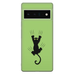 May include: A green phone case with a black cat silhouette scratching at the surface. The cat has green eyes and is hanging upside down.