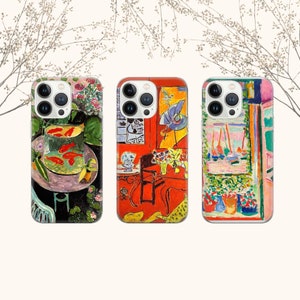 May include: Three iPhone cases with different artistic designs. The first case features a still life with goldfish in a bowl, the second case features a red chair and a still life with flowers, and the third case features a window with a view of a cityscape.