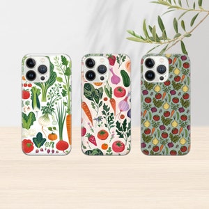 May include: Three iPhone cases featuring different colourful vegetable and fruit patterns. The first case has a white background with green, red, and orange vegetables. The second case has a white background with green, red, and orange vegetables and fruits. The third case has a green background with red, orange, and yellow vegetables and fruits.