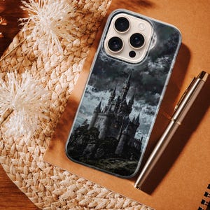 Dark fantasy phone case design depicting a gothic castle standing on a rocky hill beneath stormy clouds. The artwork uses deep black, gray, and muted blue tones to create a dramatic and mysterious atmosphere. The castle appears powerful and ancient, surrounded by mist and shadow, evoking themes of dark fantasy, mystery, and epic storytelling. This moody illustration is ideal for fans of gothic and fantasy aesthetics.