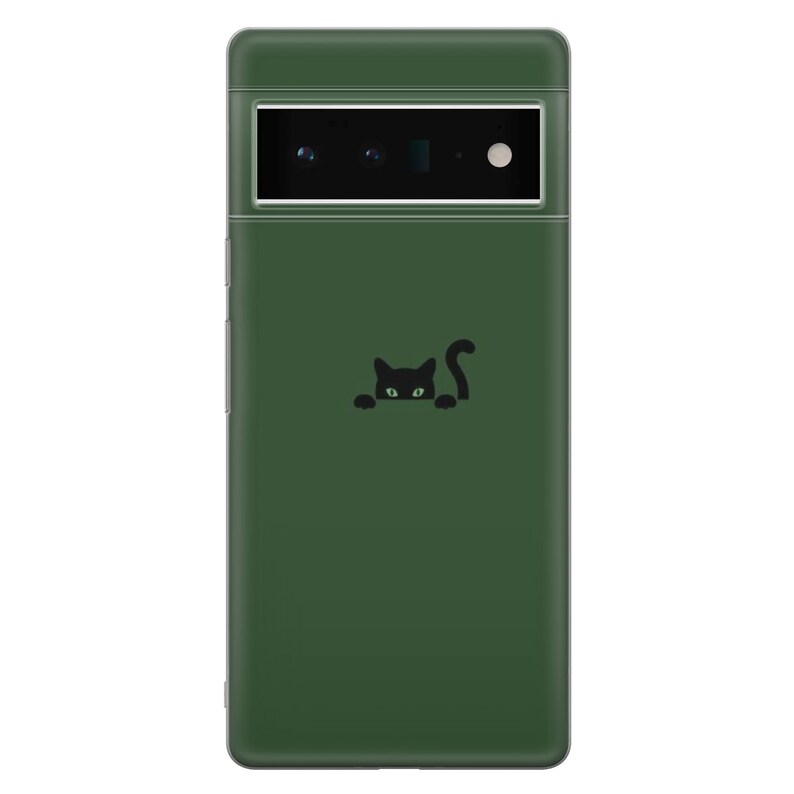 May include: A dark green phone case with a black cat peeking out from behind a corner. The cat has green eyes.