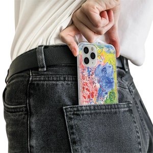May include: A clear phone case with a colorful abstract design featuring a person and flowers. The case is in a back pocket of a pair of dark gray jeans.