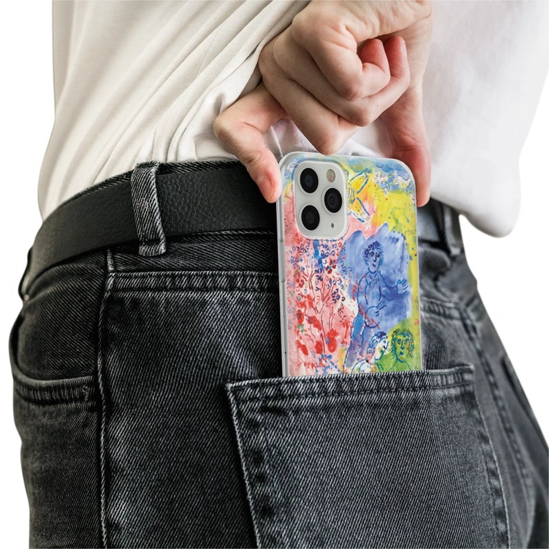 May include: A clear phone case with a colorful abstract design featuring a person and flowers. The case is in a back pocket of a pair of dark gray jeans.