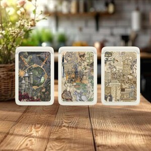 May include: Three rectangular trays with off-white frames and fantasy-themed artwork. The trays feature images of castles, swords, and vintage illustrations. The trays are displayed on a wooden surface, suggesting a decorative or functional use.