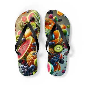 Op de afbeelding: Een paar zwarte slippers met een kleurrijk fruitontwerp. Het ontwerp bevat watermeloen, ananas, kiwi, druiven en blauwe bessen.