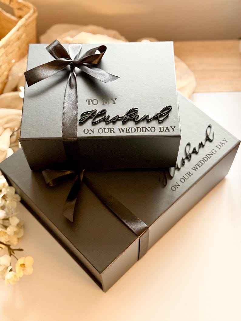 Puede incluir: Dos cajas de regalo grises, una encima de la otra, atadas con cintas de sat&eacute;n gris oscuro. La caja superior tiene las palabras "TO MY Husband ON OUR WEDDING DAY" en una fuente cursiva. La caja inferior tiene la palabra "Husband" y "ON OUR WEDDING DAY".