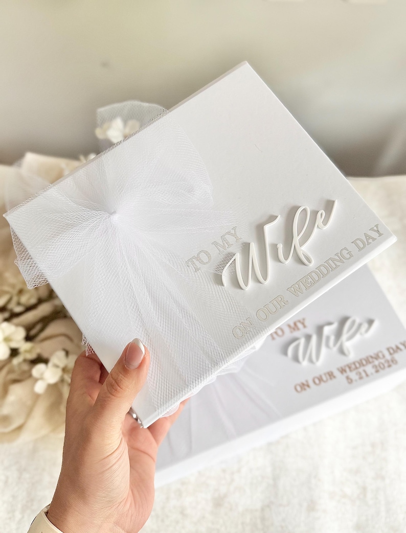 May include: White wedding keepsake box with the text "TO MY Wife ON OUR WEDDING DAY" in elegant script. The box is adorned with a delicate white tulle bow. A second box is visible with the date 5.21.2026.
