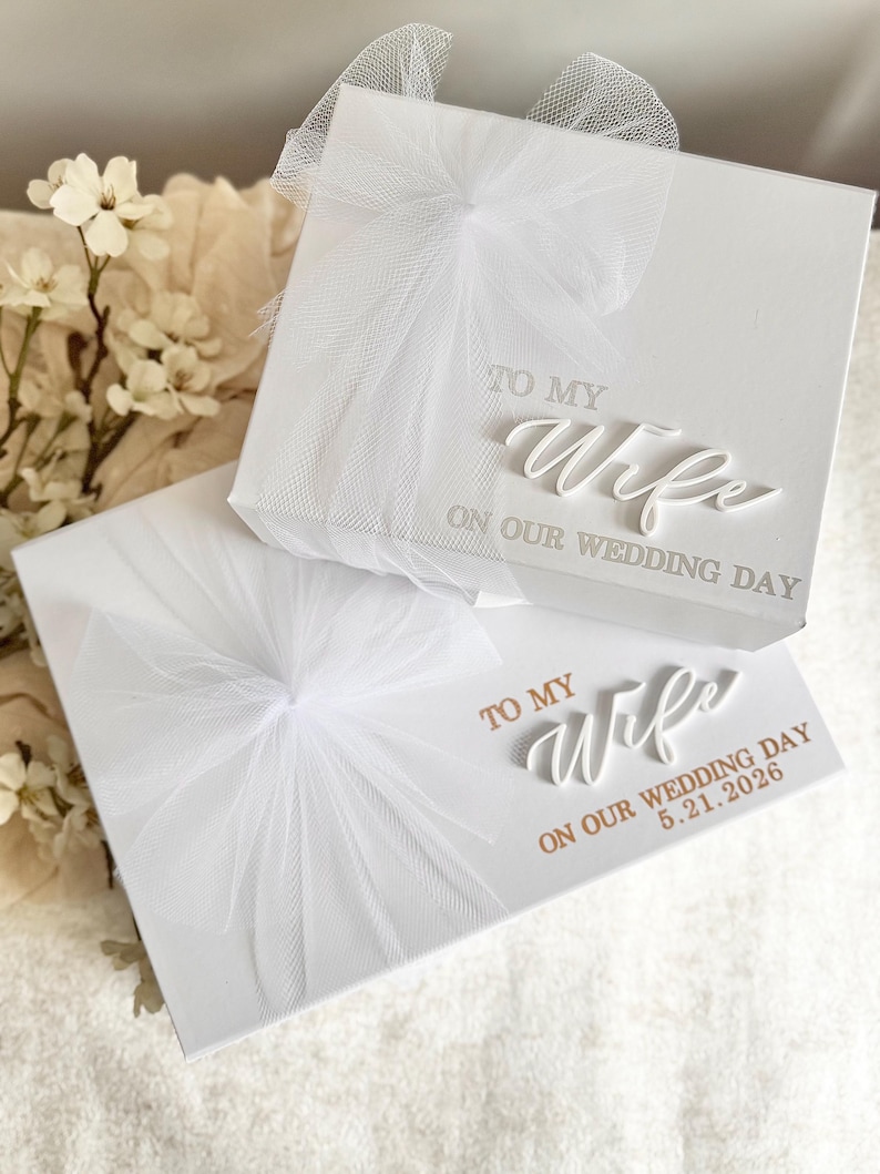 May include: Two white gift boxes with tulle bows. The top box reads "TO MY Wife ON OUR WEDDING DAY" in elegant script. The bottom box has the same text, with the addition of "5.21.2026".